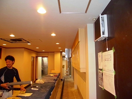 内部では設備工事の仕上げ 電気屋さんが照明器具を取り付けていきます